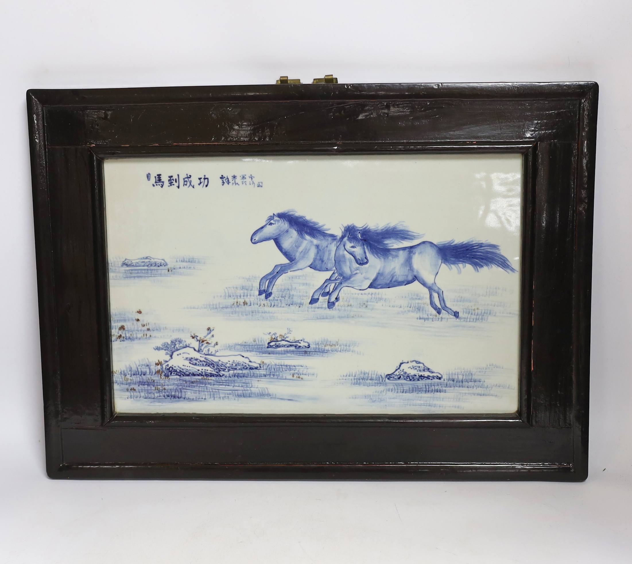 A Chinese framed blue and white porcelain panel depicting two horses, framed, overall 35 x 48cm